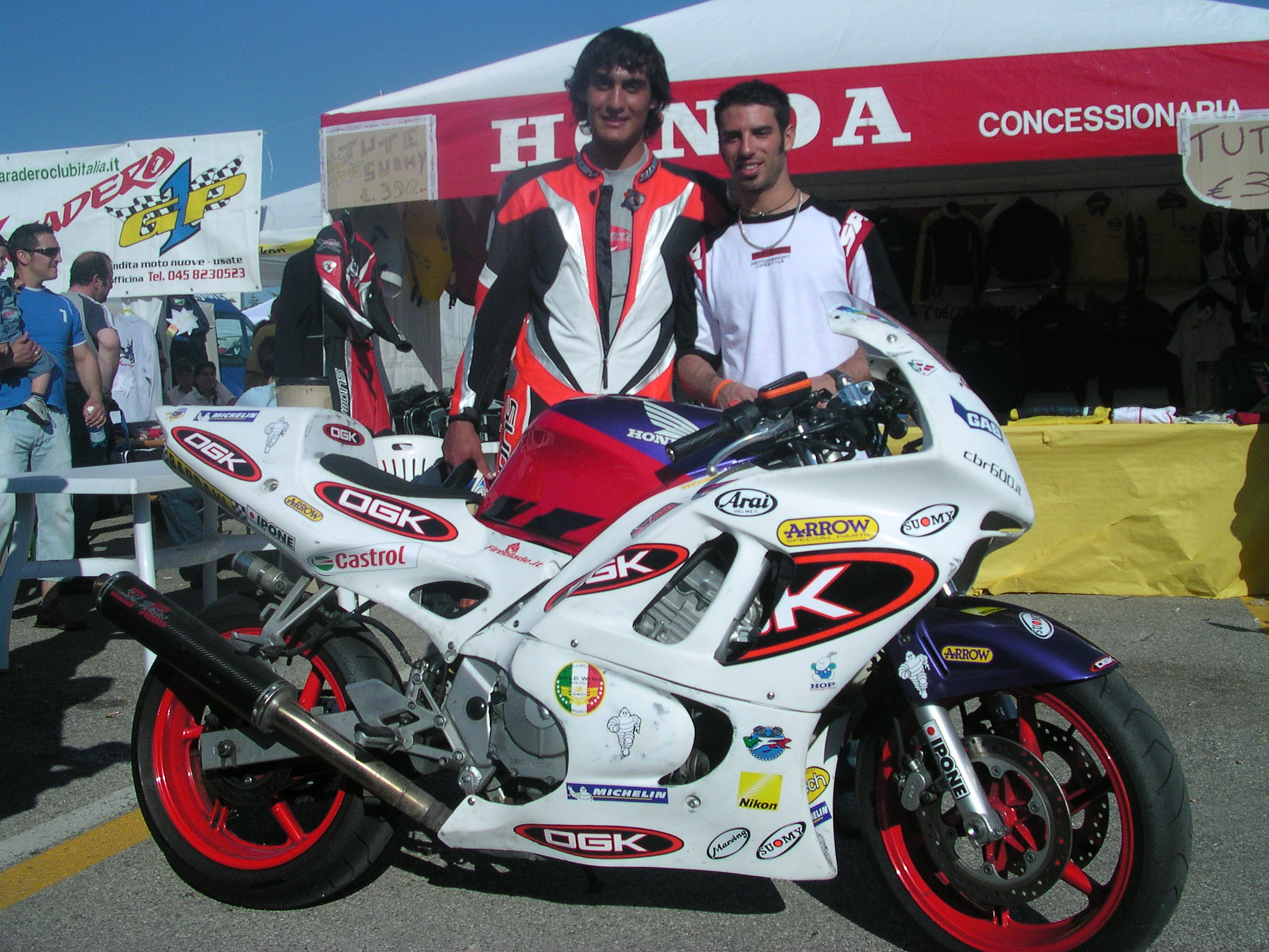Francesco con la moto da corsa davanti a un concessionario Honda
